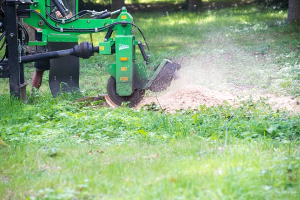 Professional stump grinding machine removing a tree stump below ground level during stump grinding and removal service in Fenton, MO.